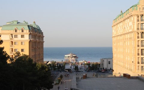 Helle Gebäude rahmen die Uferpromenade und Seebrücke von Sumqayıt vor dem Kaspischen Meer ein