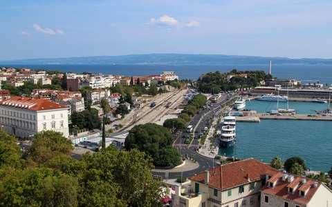 Aerial view of Split's harbour and quays with ships at berth, the town around it and the sea and islands beyond