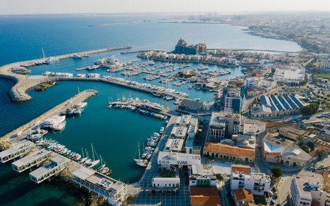Aerial view of Limassol Marina with yachts in turquoise water, the breakwater and the city along the coast