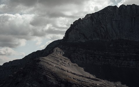 The rugged dark slopes of Mount Olympus under a dramatic cloudy sky