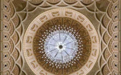 The ornate dome and grand chandelier inside the Sultan Qaboos Grand Mosque in Salalah