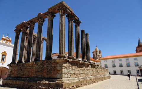 The granite columns of the Roman temple in Evora against a vivid blue sky