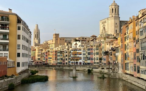 Bunte Häuser am Fluss in Girona, überragt vom Turm der Kathedrale