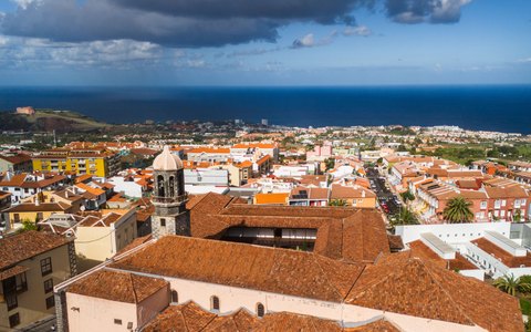 Aerial view of the rooftops and church towers of La Orotava, with the Atlantic Ocean beyond