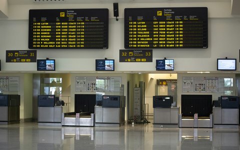 Check-in-Schalter unter Abflugtafeln im Terminal des Flughafens Menorca