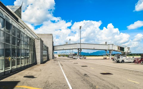 Glass terminal building and jet bridge on the apron at Krabi Airport