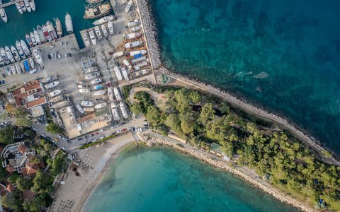 Aerial view of Kemer marina with boats, a green peninsula and turquoise sea