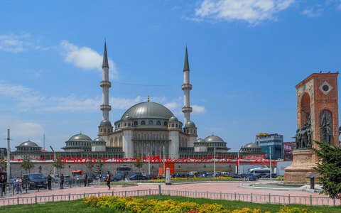 The Taksim Mosque and the Republic Monument on Taksim Square, under a blue sky with white clouds
