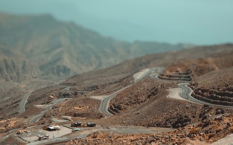 Aerial view of a road winding up the bare rocky slopes of Jebel Jais